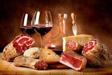 Tagliere di salumi e formaggi con calice di vino rosso